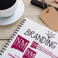 Clipboard with the word "branding" and NMSU logos on it.